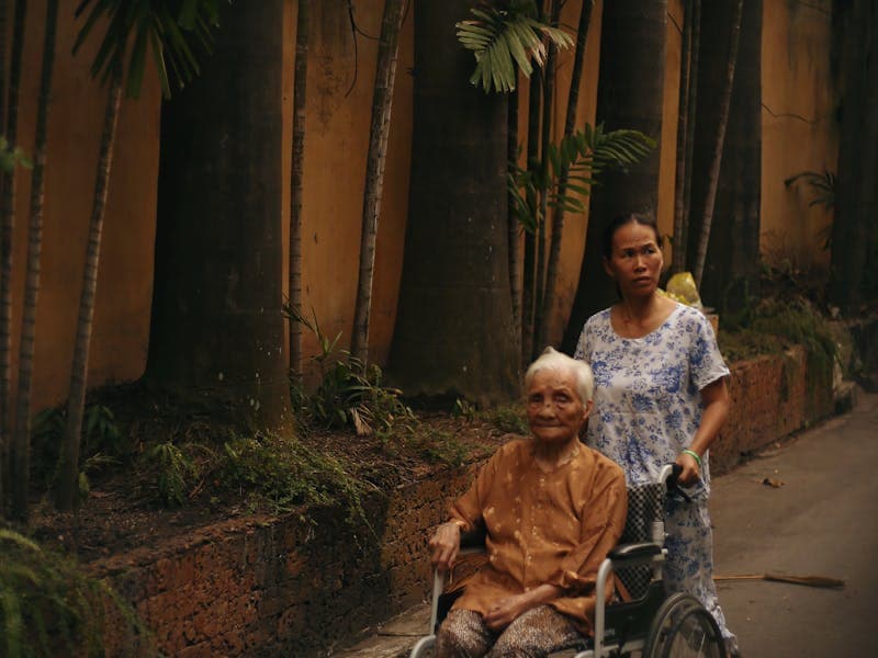 Caregiver assisting elderly patient in wheelchair